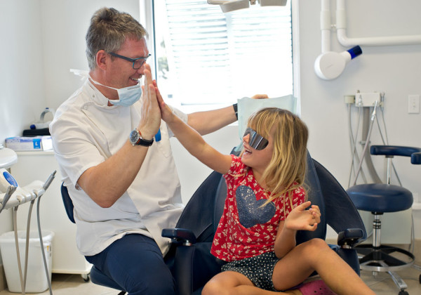 Dr Mark Osmond sharing a high-five with a young patient